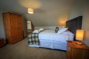 a bedroom with a bed and a cabinet and a lamp at Cosy Cottage in Fishertown, Nairn - Free Parking & Pets welcome in Nairn