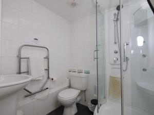 a bathroom with a toilet and a sink and a shower at The Five Bells, Eastry in Sandwich