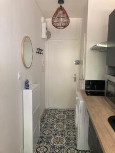Łazienka z białymi drzwiami i podłogą wyłożoną kafelkami w obiekcie Studio 5 min du centre-ville w La Rochelle