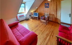 a living room with a red couch and a television at 3 Bedroom Awesome Home In Plourivo in Plourivo +17 photos
