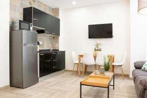 a kitchen and living room with a stainless steel refrigerator at AP HOTEL NAVAS in Alicante