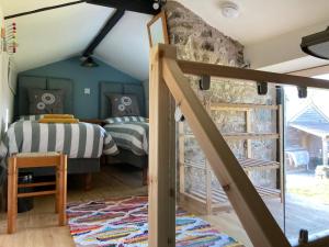 a bedroom with two beds and a stone wall at The Rowe House in Horton in Ribblesdale