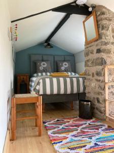 a bedroom with a bed and a stone wall at The Rowe House in Horton in Ribblesdale