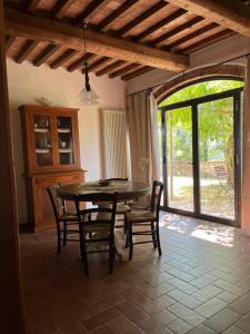 d'une salle à manger avec une table, des chaises et une fenêtre. dans l'établissement Agriturismo I Moricci, à Peccioli