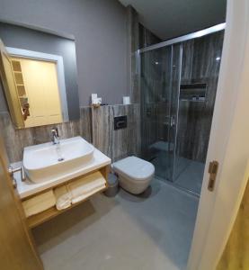 a bathroom with a sink and a shower and a toilet at Hotel Doğa Çeşme in Çeşme