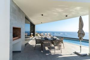 a dining room with a view of the ocean at Villa Estrelícia by LovelyStay in Ribeira Brava
