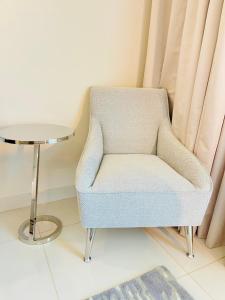 a chair in a living room with a table at D3001 Paramount hotel residence 5 star luxury 2bedroom close to Burj Khalifa and Dubai mall in Dubai