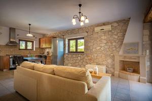 a living room with a couch and a fireplace at Kymaros Villas in Keri