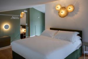 a bedroom with a white bed and two mirrors at Montegrottone Resort & Spa in Polignano a Mare