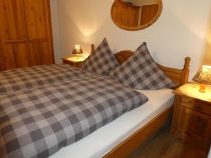 ein Schlafzimmer mit einem Bett mit karierten Kissen darauf in der Unterkunft Haus Abendsonne Familie Druxes in Krün