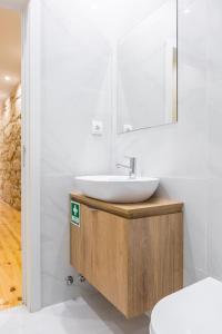 un bagno con lavandino e specchio di ORM Carregal Apartment a Porto