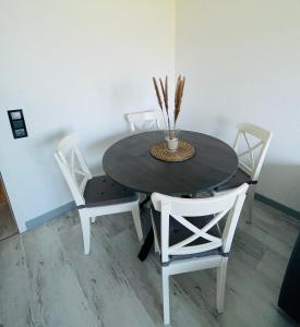 un tavolo da pranzo con due sedie e un tavolo con una pianta di Apartment Seesrauschen für 2-4 Personen mit Pool a Dahme