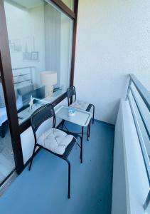 una camera con due sedie e un tavolo sul balcone di Apartment Seesrauschen für 2-4 Personen mit Pool a Dahme