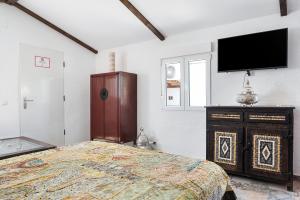 a bedroom with a bed and a flat screen tv at Villa Egipto in Chiclana de la Frontera