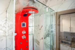 a red shower in a bathroom with a glass wall at Villa Egipto in Chiclana de la Frontera +16 photos