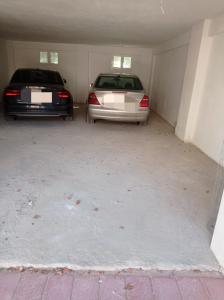 Dos autos están estacionados en un garaje. en Deluxe Apartments 1, en Orfánion