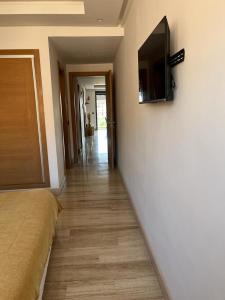 - un couloir avec un lit et une télévision murale dans l'établissement Superbe appartement à l Hivernage, à Marrakech