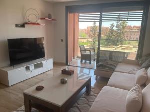 - un salon avec un canapé et une télévision dans l'établissement Superbe appartement à l Hivernage, à Marrakech