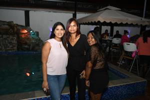 three women standing next to a pool at a party at Metro Hotel Couva in Couva