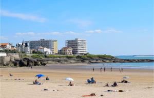a group of people on a beach with umbrellas at Amazing Apartment In Vaux-Sur-Mer in Vaux-sur-Mer