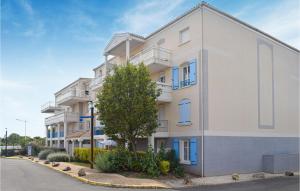 an apartment building with a tree in front of it at Amazing Apartment In Vaux-Sur-Mer in Vaux-sur-Mer +10 photos
