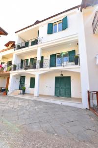 biały budynek z zielonymi drzwiami i balkonami w obiekcie Chez Luke Apartments in Agerola w mieście Agerola