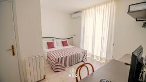 a small bedroom with a bed and a window at MIIO HOTEL in San Vincenzo