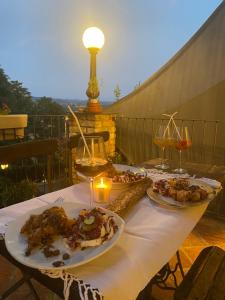 uma mesa com dois pratos de comida e copos de vinho em I CATARI ...nel cuore di Monforte d'Alba em Monforte dʼAlba