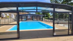 een zwembad in een paviljoen met een zwembad bij Nature Holiday's Domaine L'OREE d'ARZAL in Arzal