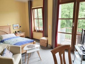 ein Schlafzimmer mit einem Bett, einem Tisch und einem Sofa in der Unterkunft Ferienwohnung Am Golfplatz 18 in Wittenbeck