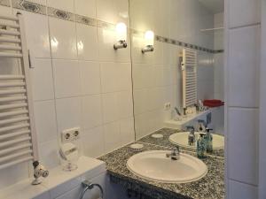 a white bathroom with a sink and a mirror at Ferienwohnung Am Golfplatz 18 in Wittenbeck
