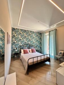 um quarto com uma cama com uma parede floral em B&B Vittoria em Anzio