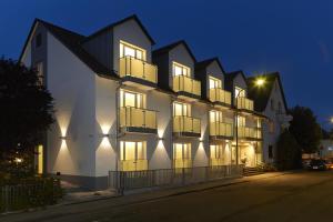 un gran edificio blanco con ventanas por la noche en Wohlfühl-Hotel Neu Heidelberg, en Heidelberg