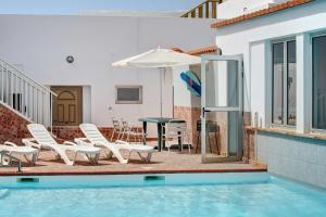a pool with chairs and a table and an umbrella at Casa Carmencita in La Garita