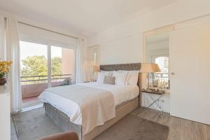 sypialnia z dużym łóżkiem i balkonem w obiekcie Apartamento Gandarinha junto ao Mar w mieście Cascais
