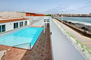 a swimming pool on top of a building next to the ocean at Casa Carmencita in La Garita