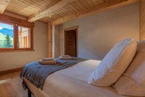 ein Schlafzimmer mit einem Bett, auf dem zwei Handtücher liegen in der Unterkunft Chalet Les Bognettes 10 personnes in Le Grand-Bornand