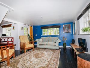 a living room with blue walls and a couch at The Cottage in Bodmin