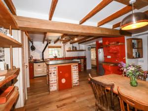 a kitchen with a wooden table and a dining room at The Cottage in Bodmin