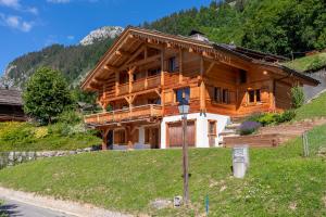 ein großes Holzhaus auf einem Hügel in der Unterkunft Chalet Les Bognettes 10 personnes in Le Grand-Bornand