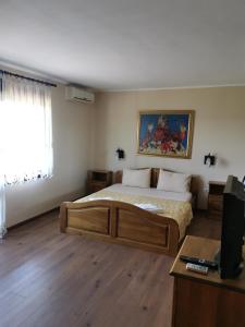 a bedroom with a large bed and a window at Family Hotel Arbanashka Sreshta in Arbanasi