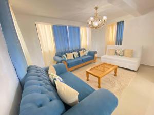 sala de estar con sofá azul y mesa en 8 Adorable Y Comfortable Apt Para Su Disfrute, en Santiago de los Caballeros