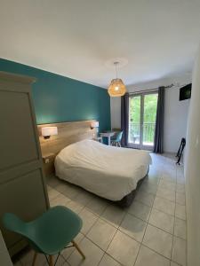 a bedroom with a white bed and a blue wall at Hotel de la Jonte in Meyrueis