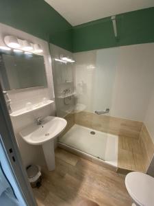 La salle de bains est pourvue d'un lavabo, d'une baignoire et de toilettes. dans l'établissement Hotel de la Jonte, à Meyrueis