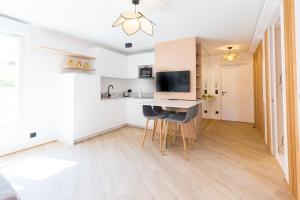 eine Küche und ein Wohnzimmer mit einem Schreibtisch und Stühlen in der Unterkunft VILLA RENAISSANCE - MONACO - 2 PIECES - Parking in Beausoleil