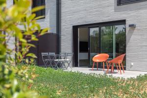 dos sillas naranjas y una mesa frente a un edificio en Reckenthal House by Rentaroo, en Luxemburgo