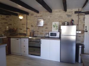 y cocina con nevera y microondas. en Reids Retreat en La Roche-lʼAbeille