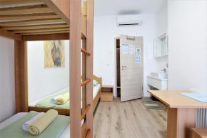 Habitación pequeña con litera y escritorio. en Hostel Soline en Portorož