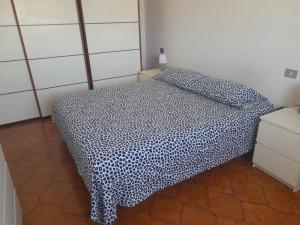 レッジョ・エミリアにあるA casa di Annamariaのベッドルーム1室(青と白の毛布付きのベッド1台付)