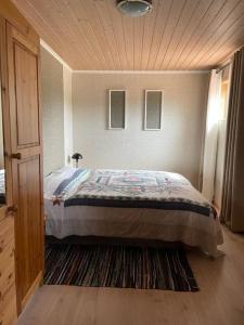 een slaapkamer met een bed en een houten plafond bij Sandve in Sandve